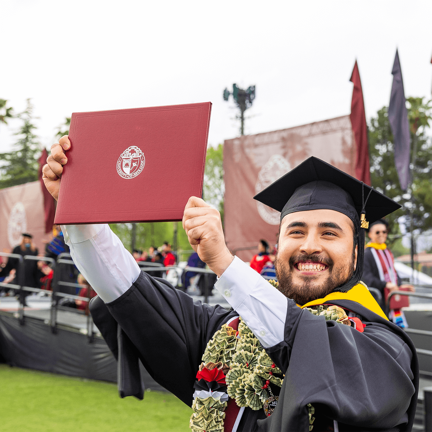 U of R Graduate proudly holding up diploma