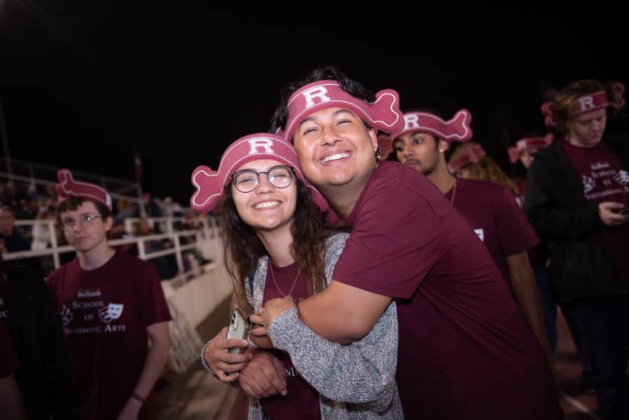 a man hugging a woman with a hat on