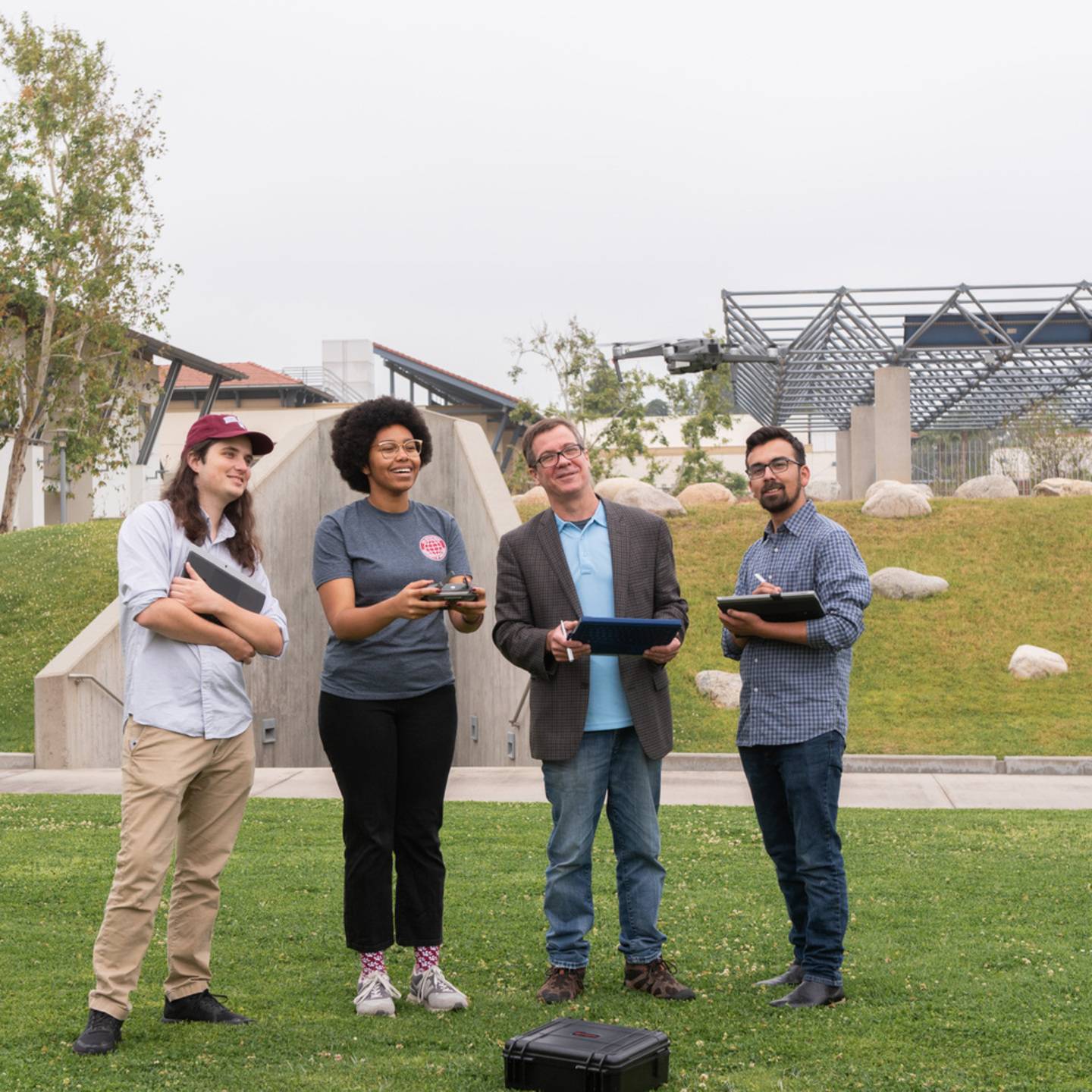 Students and instructor flying a drone near Lewis Hall.