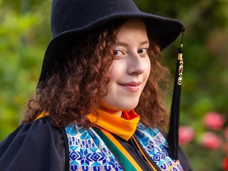 a woman wearing a black hat and gown
