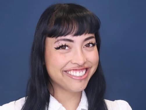 a woman with piercings and nose ring smiling