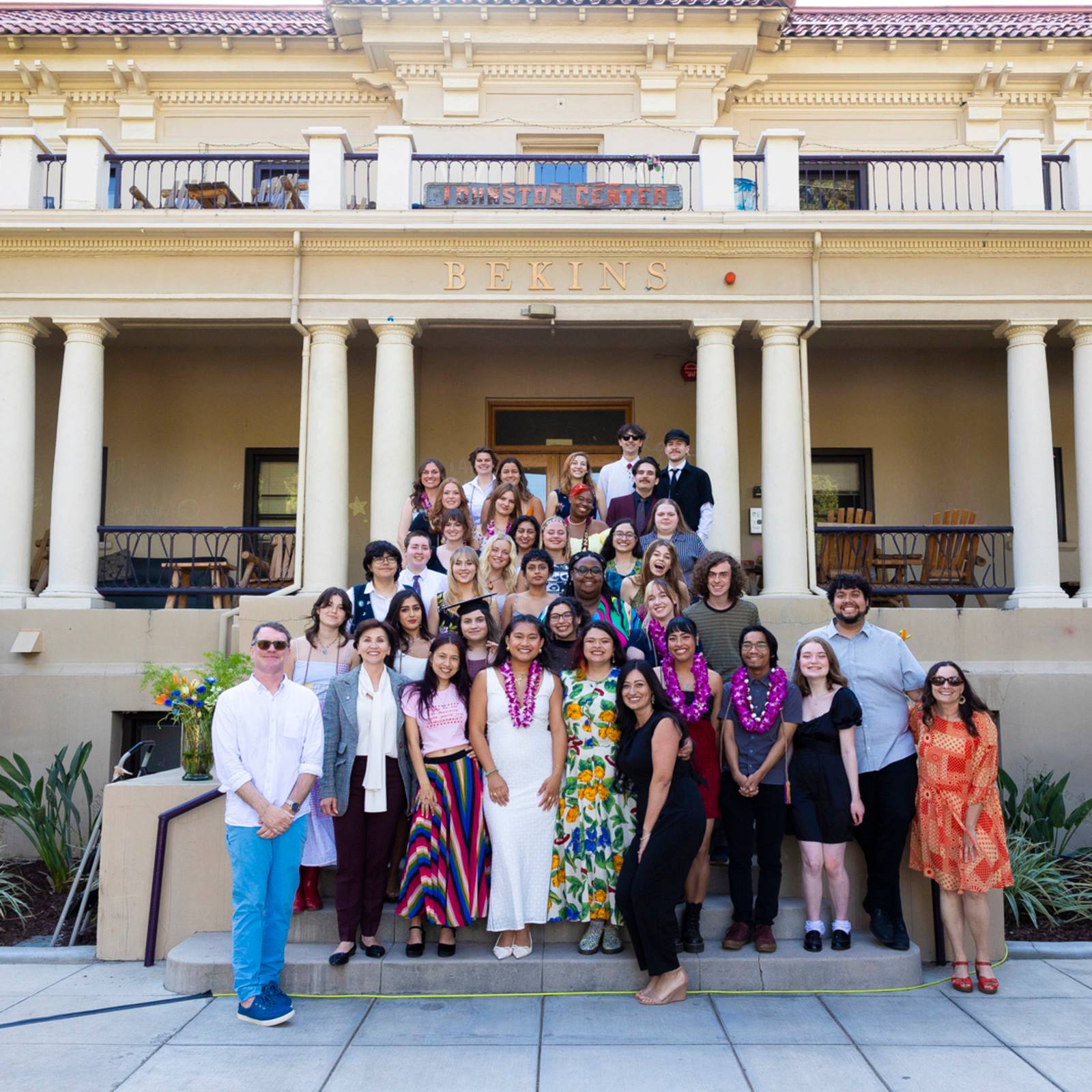 a group of people posing for a photo in front of a building