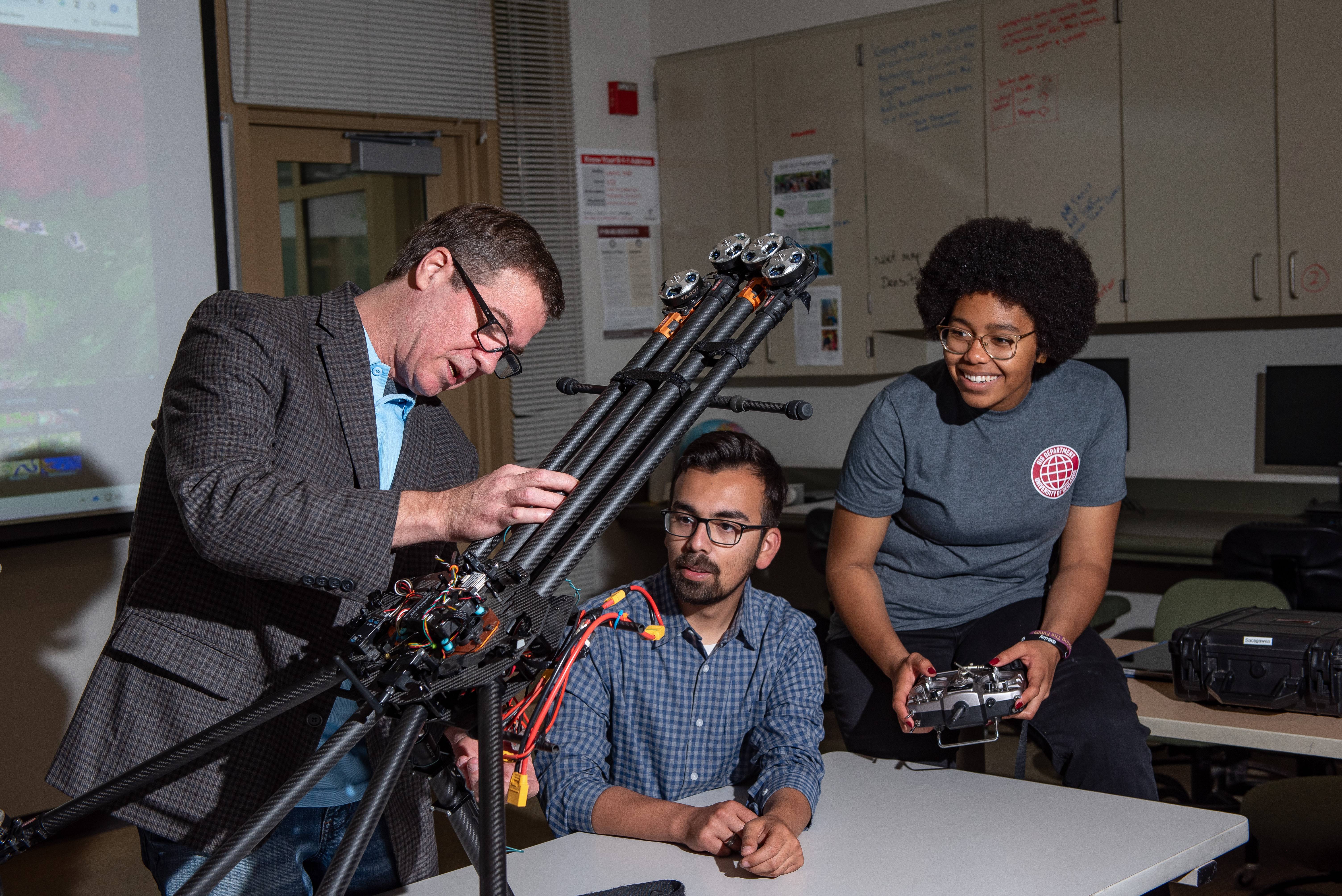 a man standing next to a man holding a machine