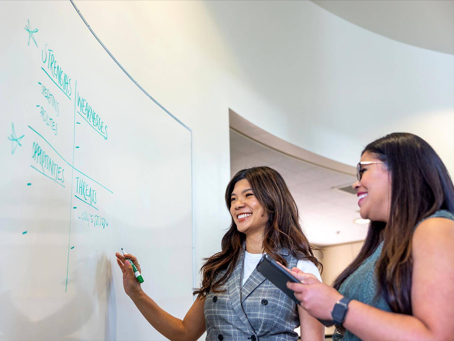 a group of women writing on a whiteboard
