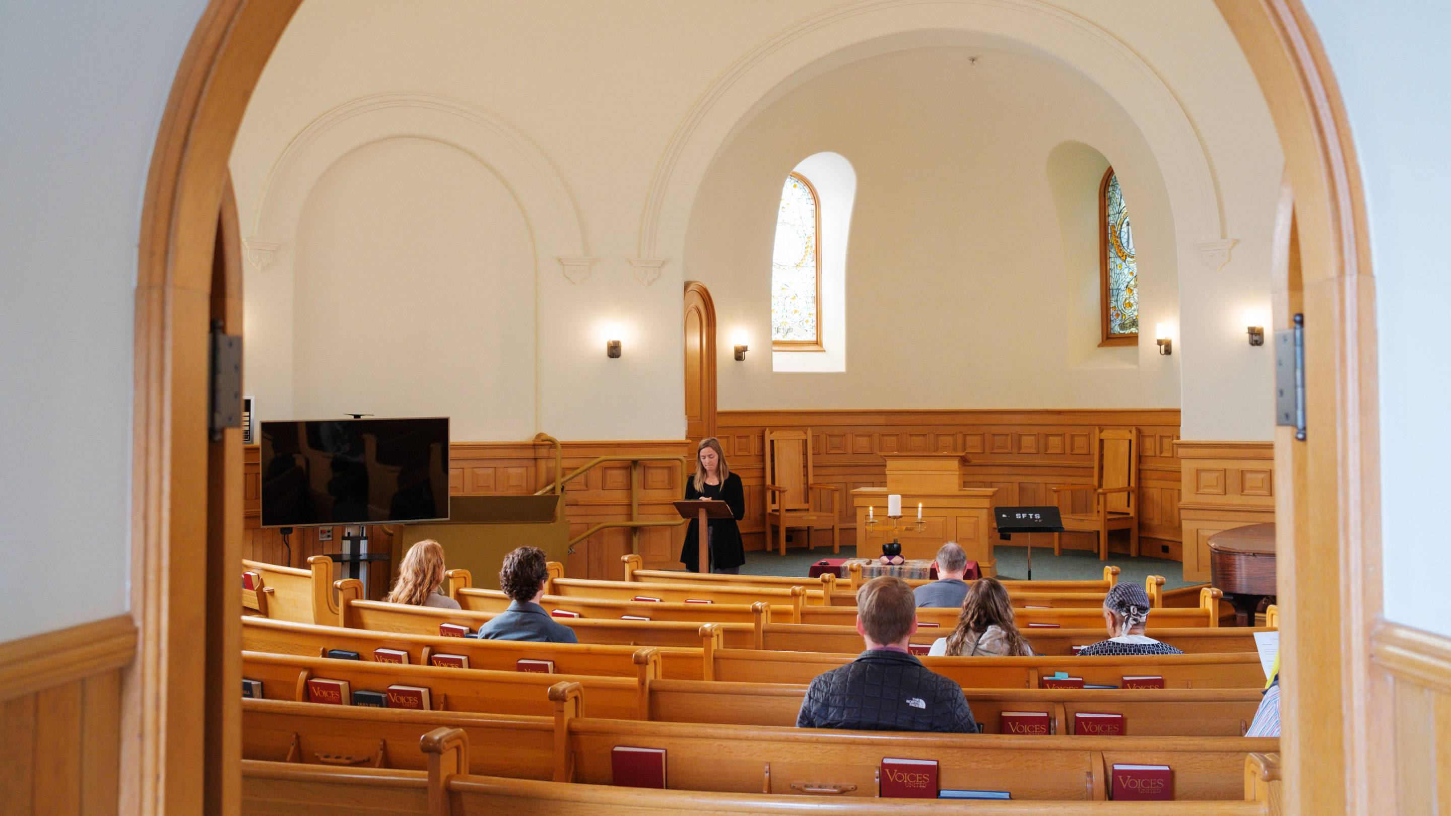 a woman standing at a podium in a church