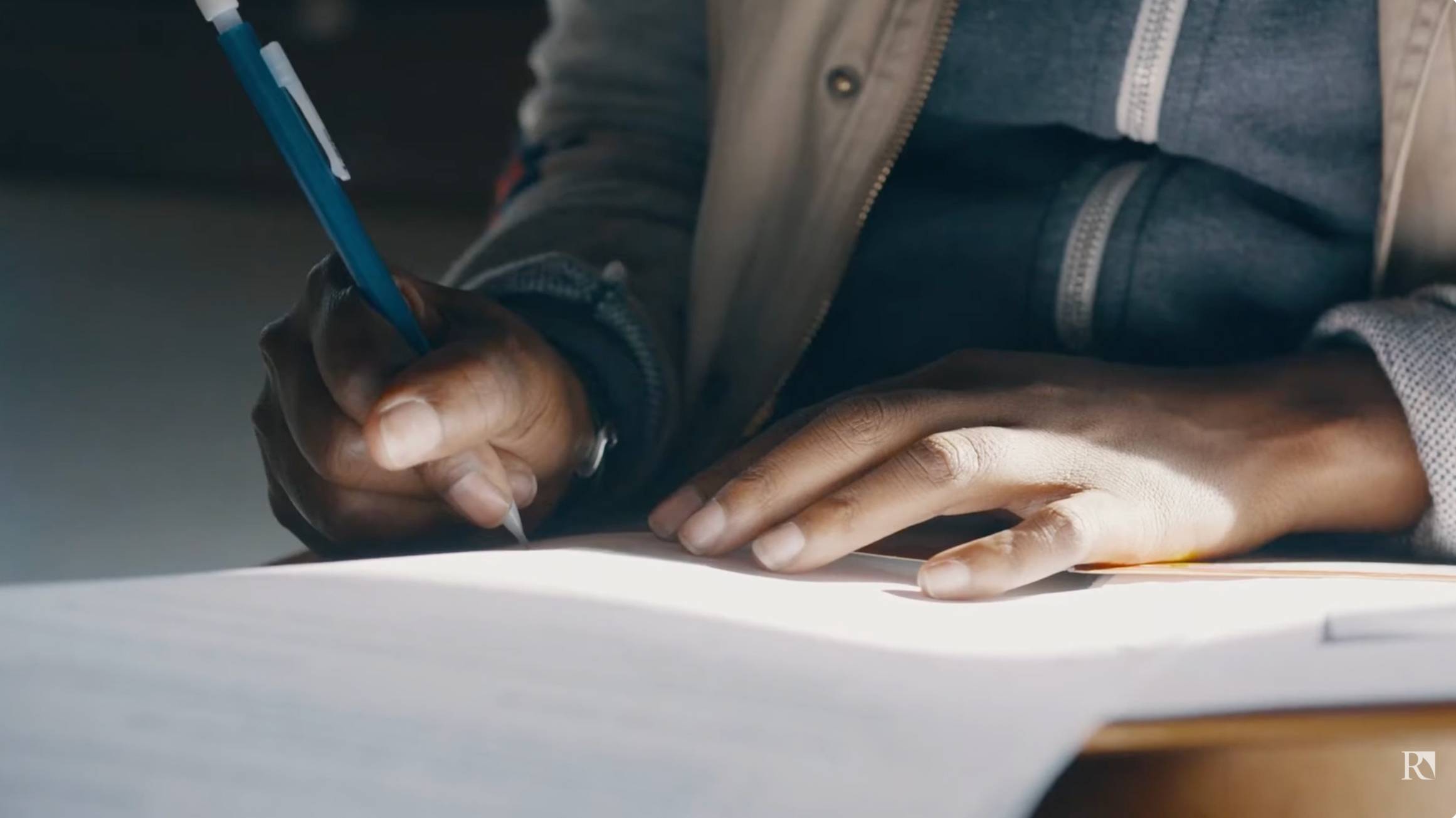 a person writing on a piece of paper