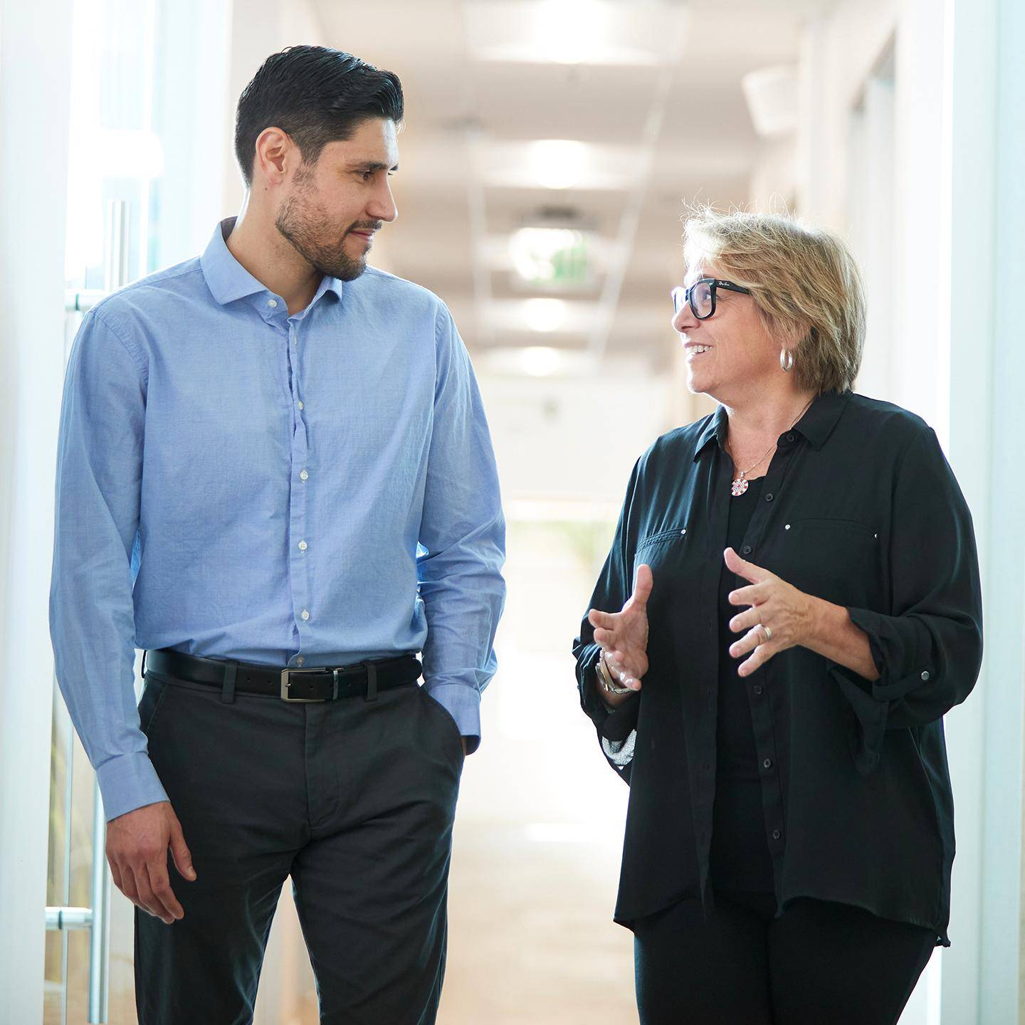 a man and woman talking in a hallway