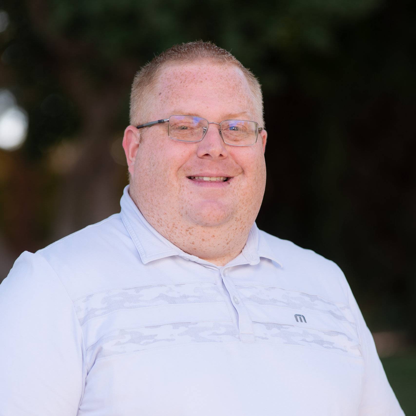 a man wearing glasses and a white shirt