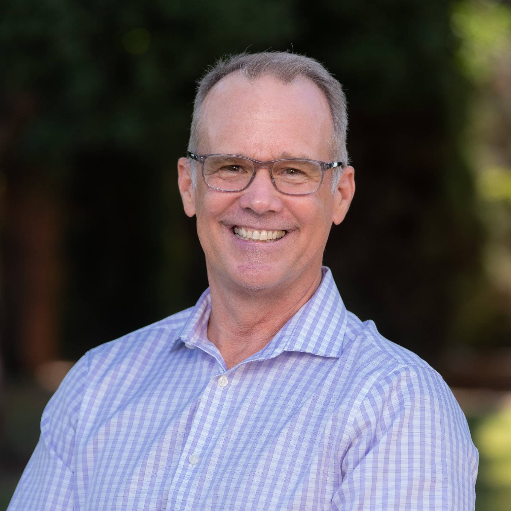 a man wearing glasses smiling