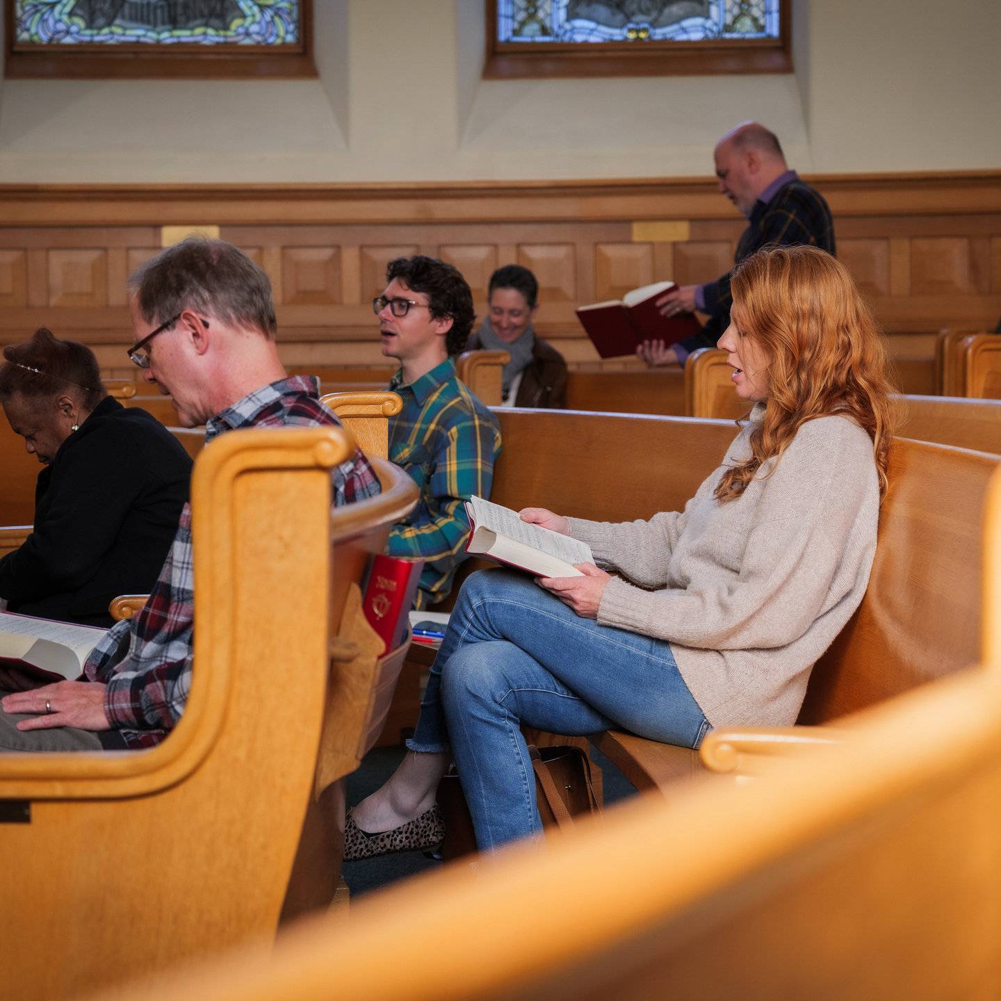 a group of people sitting in pews reading books