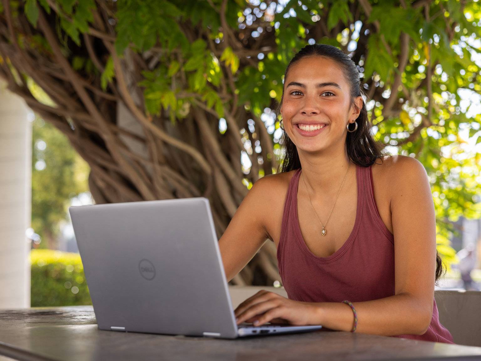 a woman sitting at a table with a laptop