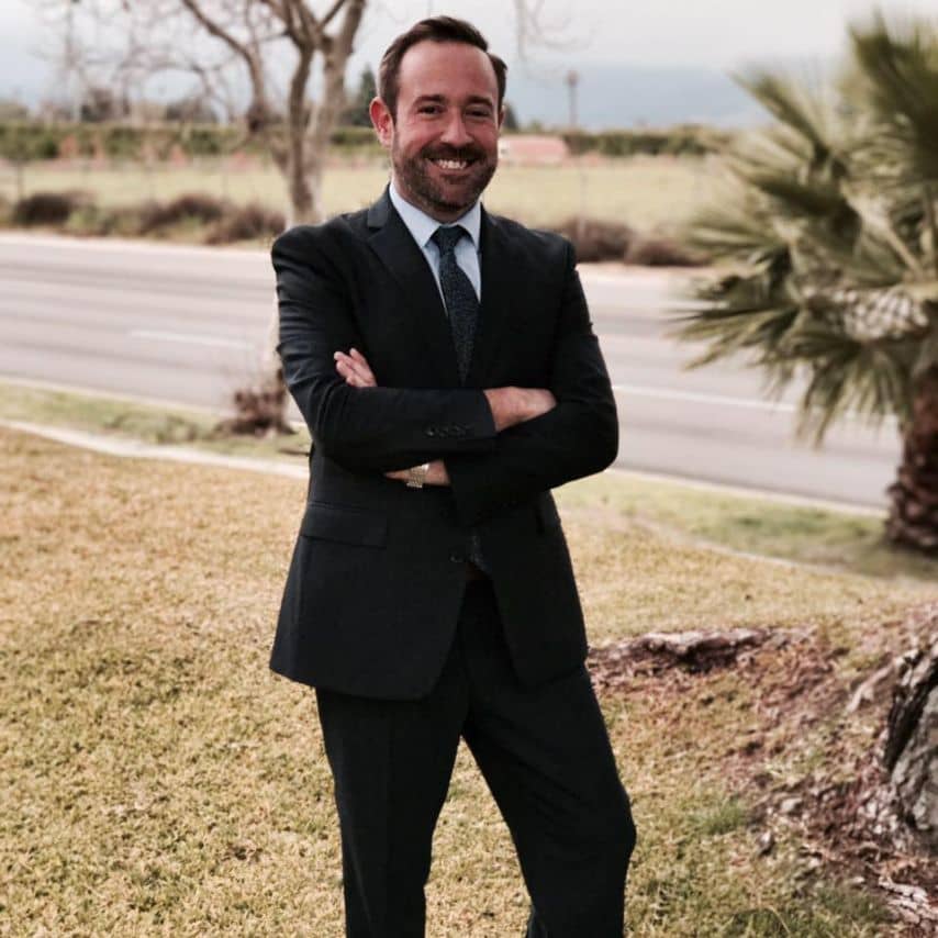 a man in a suit standing with his arms crossed