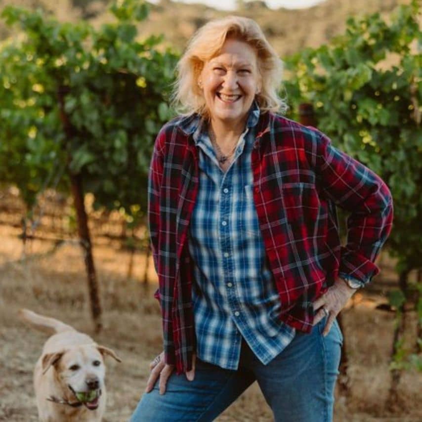 a woman standing next to a dog