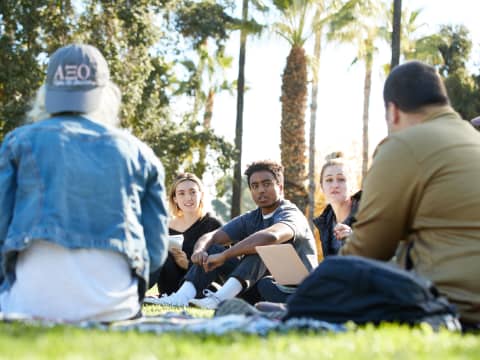 a group of people sitting on the grass