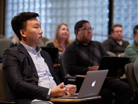 a man sitting in front of a laptop