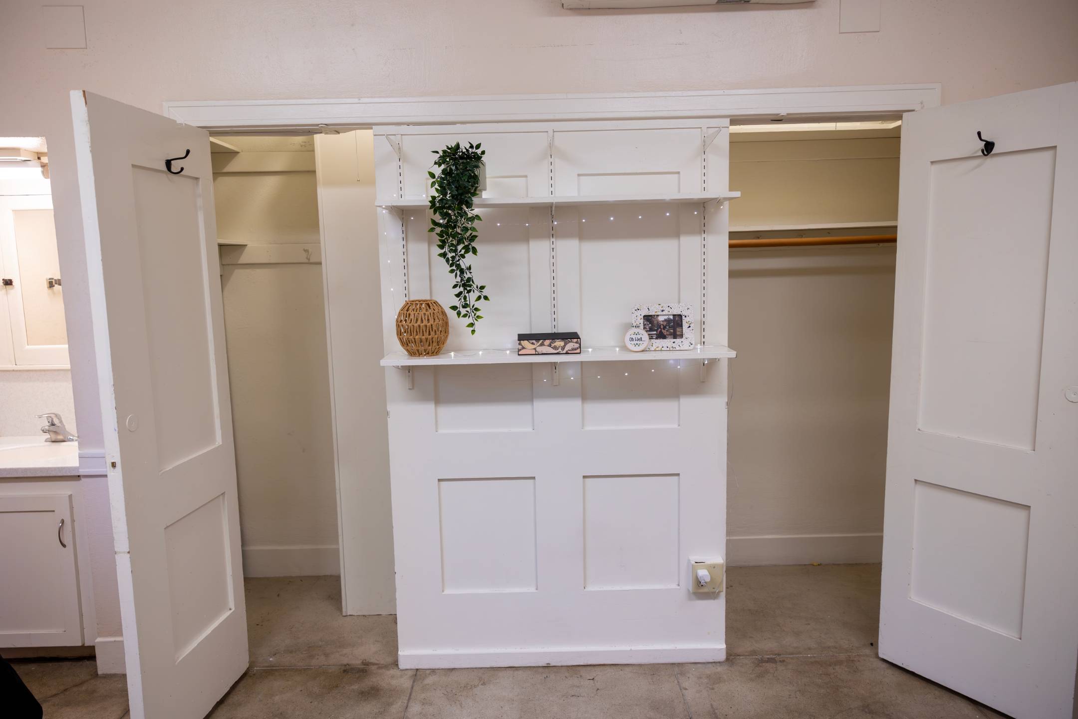 a white shelf with a plant on it