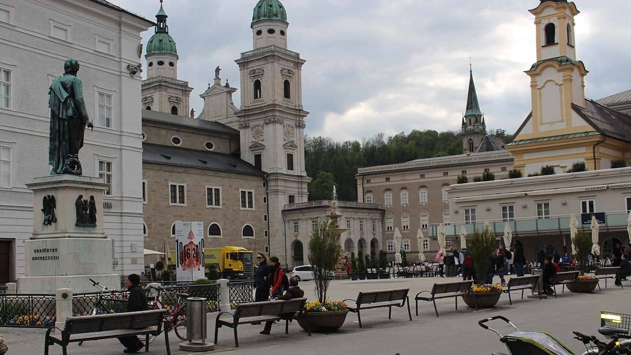 a group of people sitting on benches in front of a building