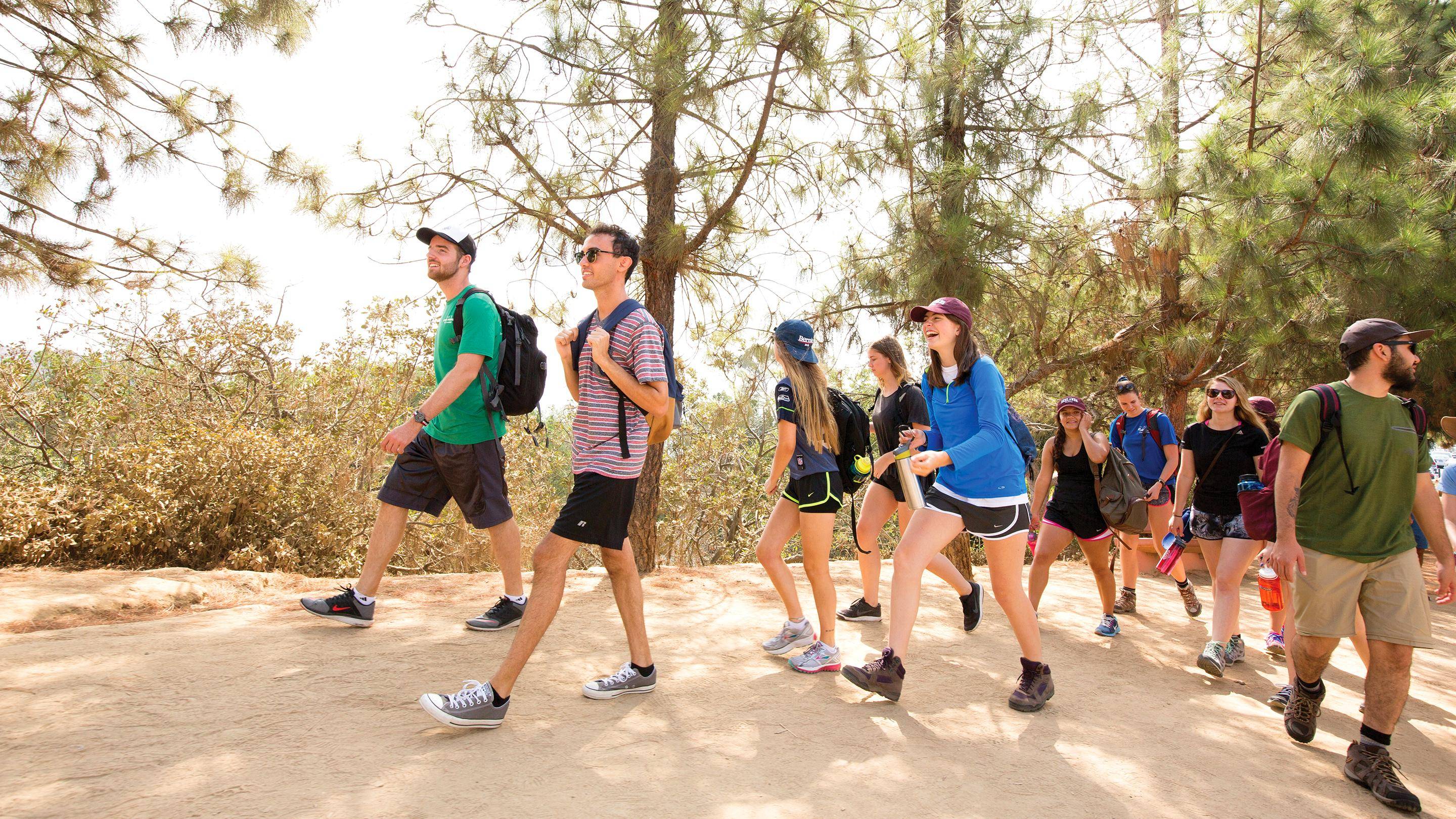 a group of people walking on a dirt path