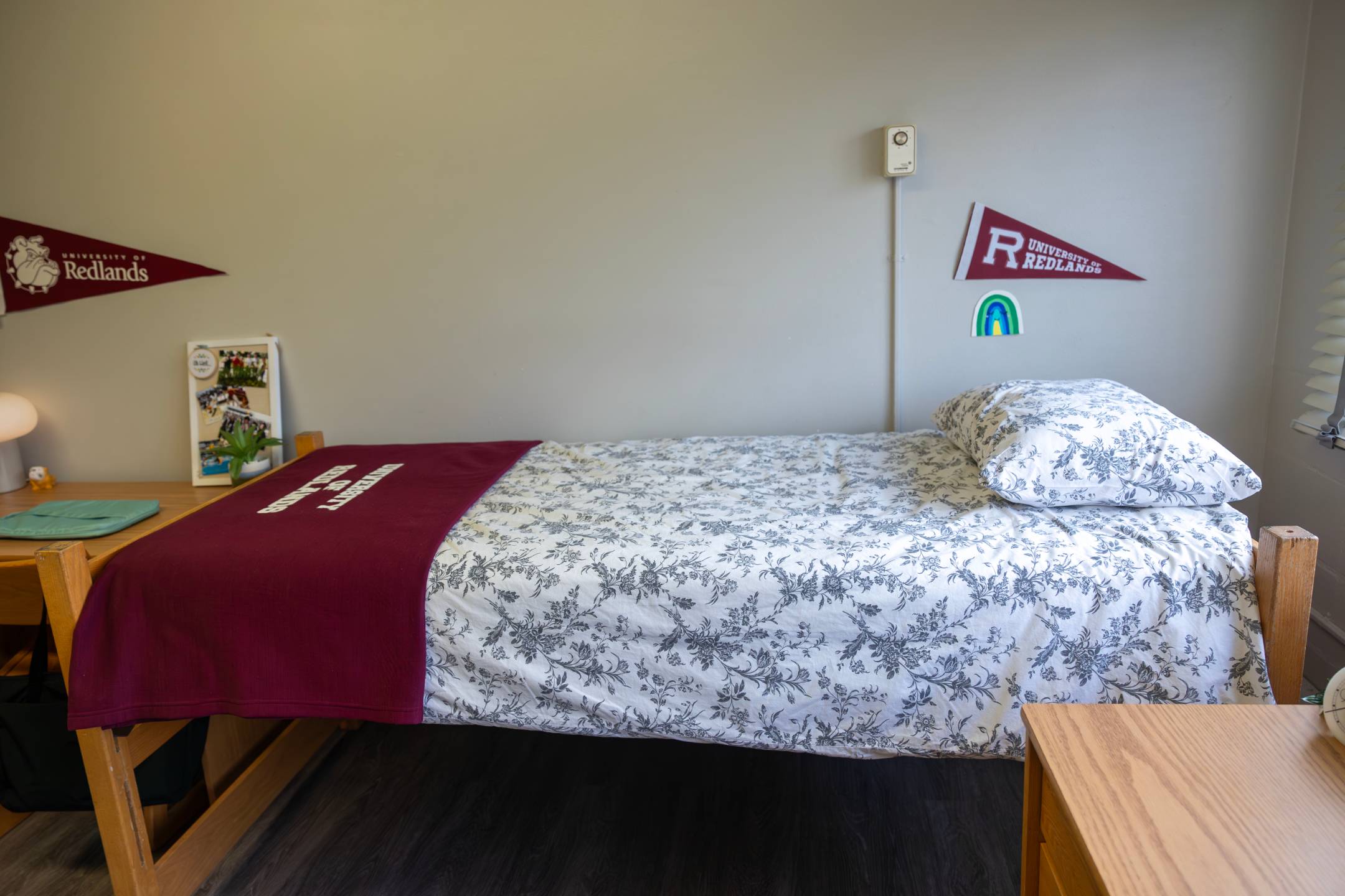 a bed with a red blanket and a flag on the wall