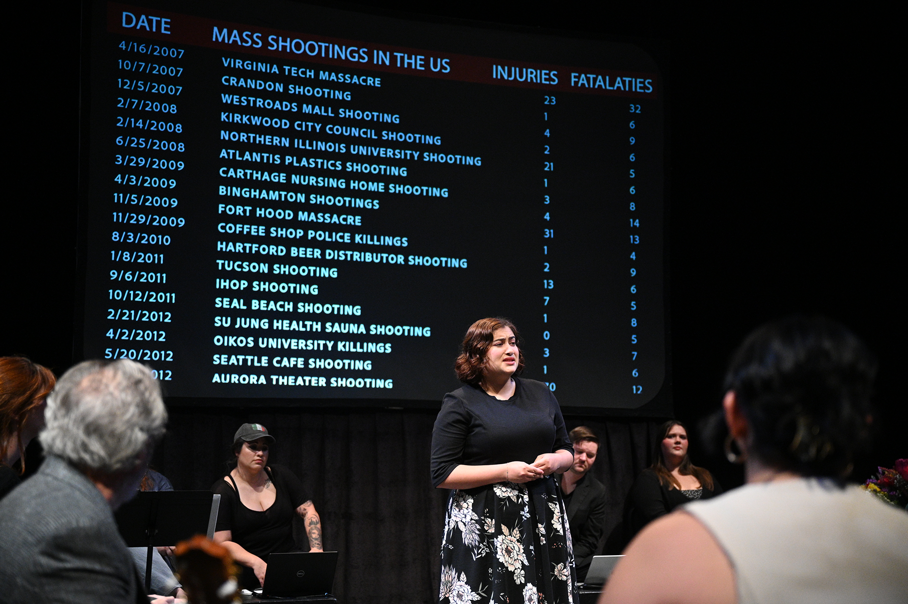 a woman standing in front of a large screen
