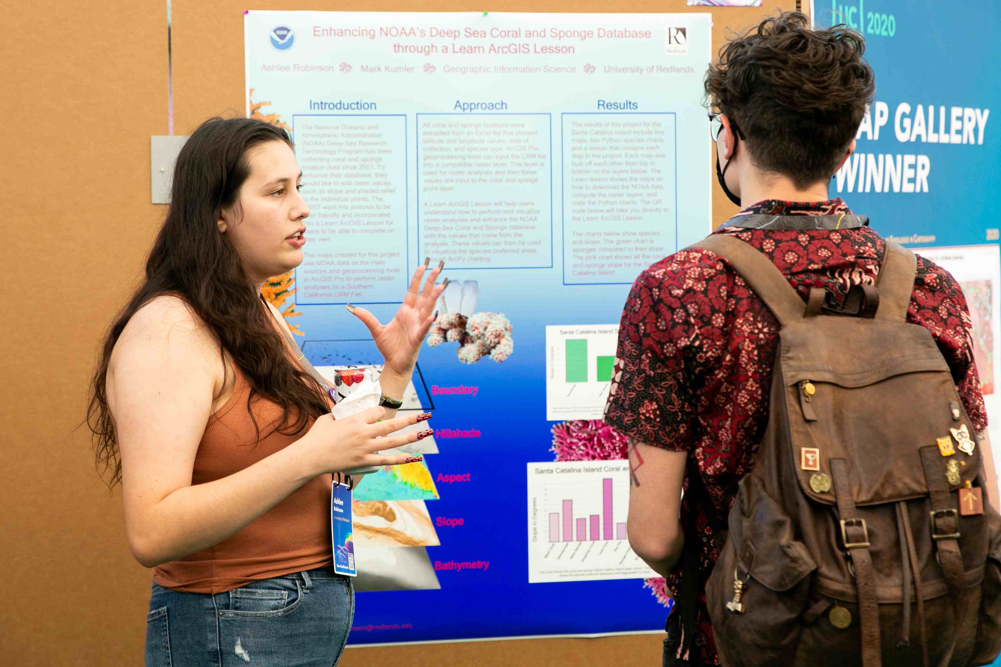 a woman and man standing in front of a poster